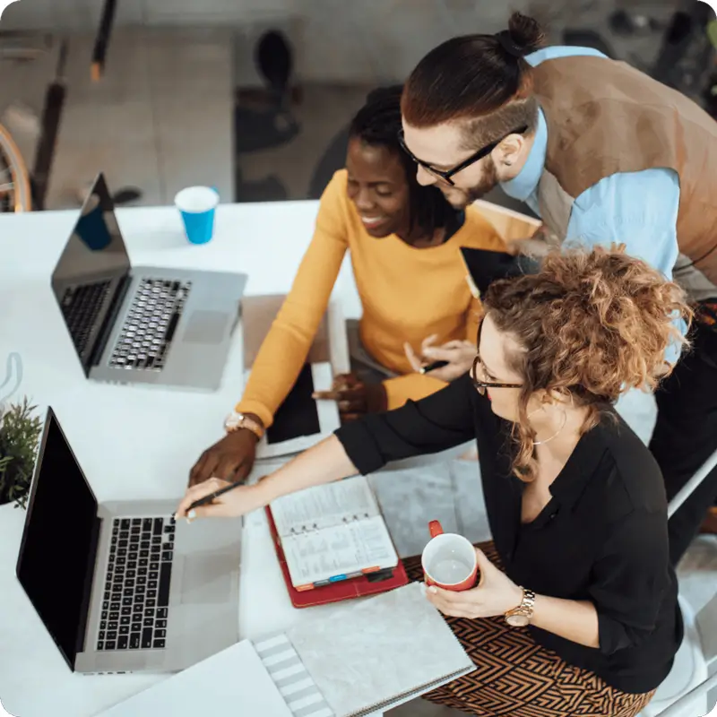 3 people in a meeting looking at a laptop